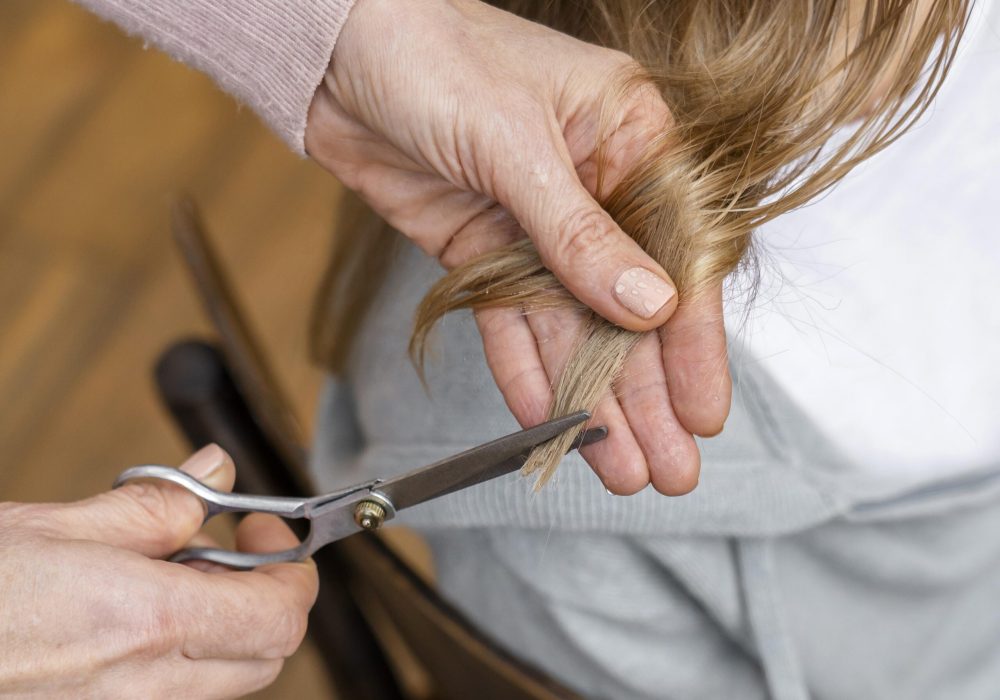 alto-angulo-de-mujer-cortandose-el-pelo