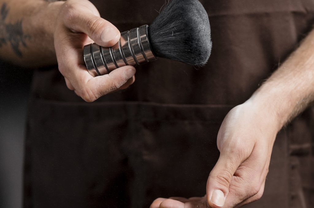 primer-plano-de-un-peluquero-mano-tenencia-cepillo-de-afeitar